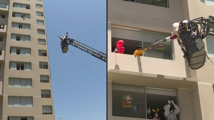 Santa Claus delivers gifts to children with covid-19 in Peru on a fire ladder